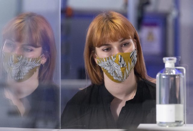 Lady wearing a mask looks at a display at the Our Future Planet exhibition at London's Science Museum