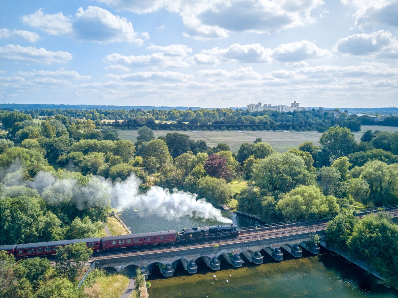 Steam rail train crosses bridge near Windsor Castle