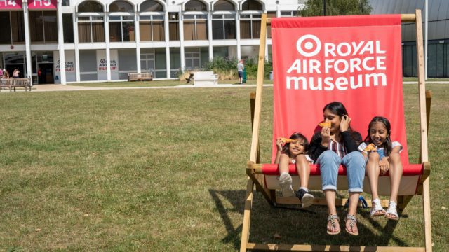 Family sit on a giant deckchair at RAF Museum London