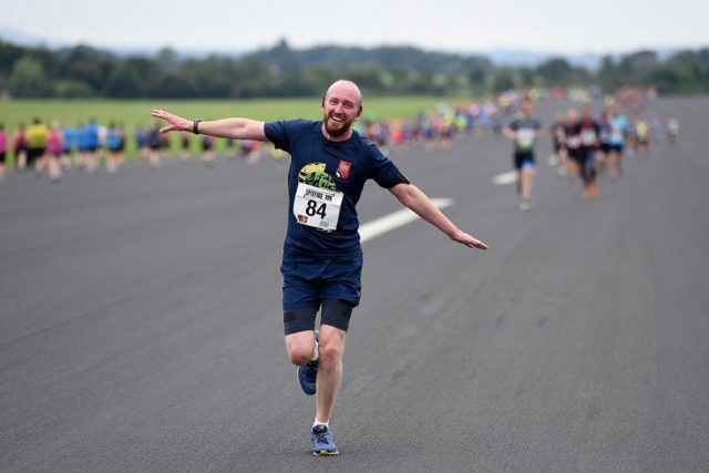 RAF Museum Spitfire 10K runner, runs with arms outstretched like an airplane