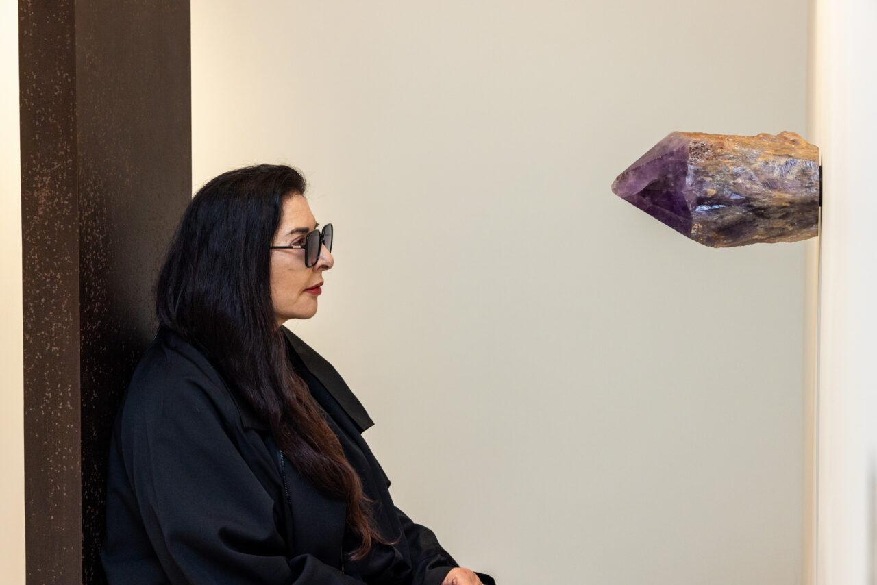 Marina Abramović sits on one of her artworks that make up the Healing Frequencies exhibition